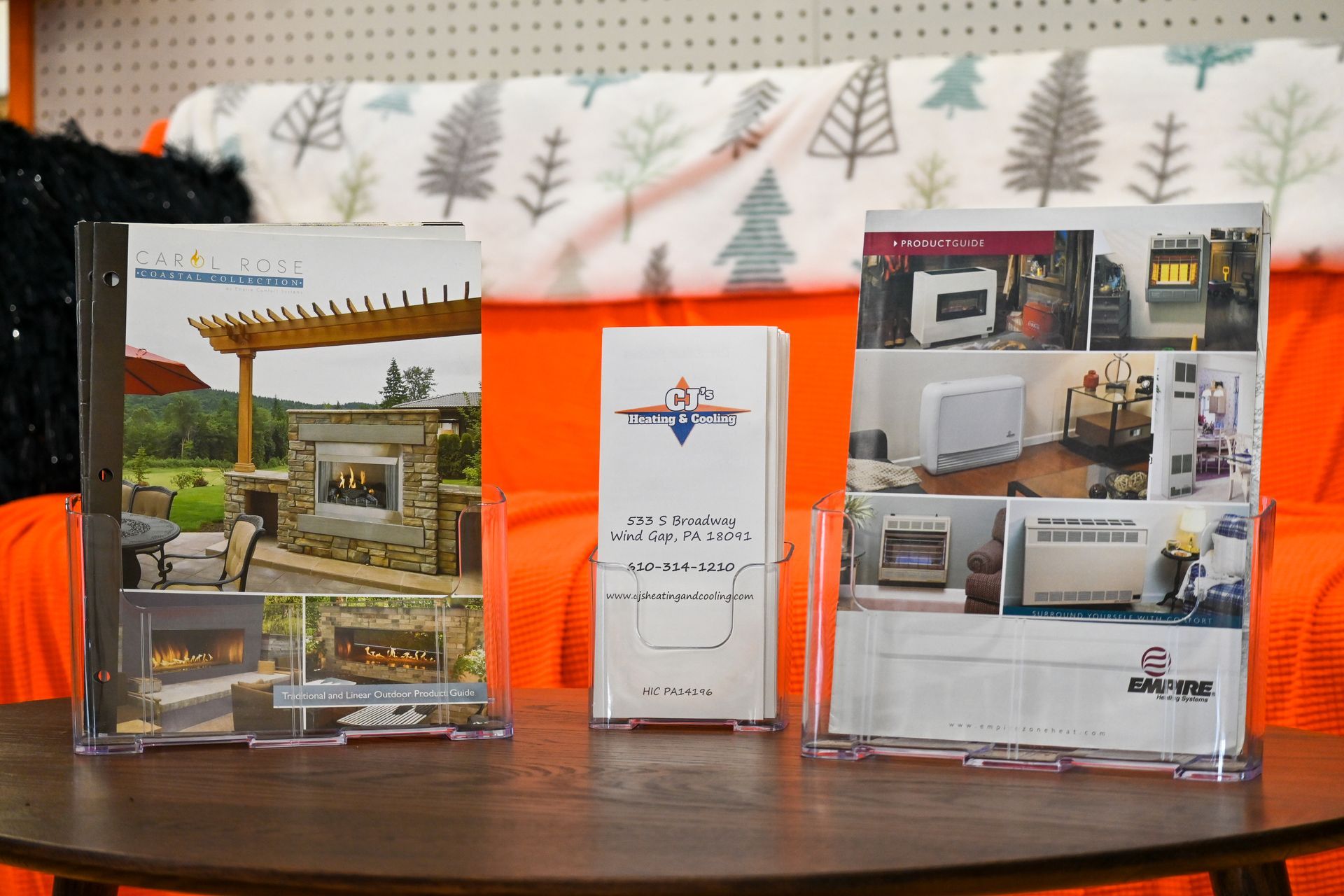 Three brochures are sitting on a wooden table.