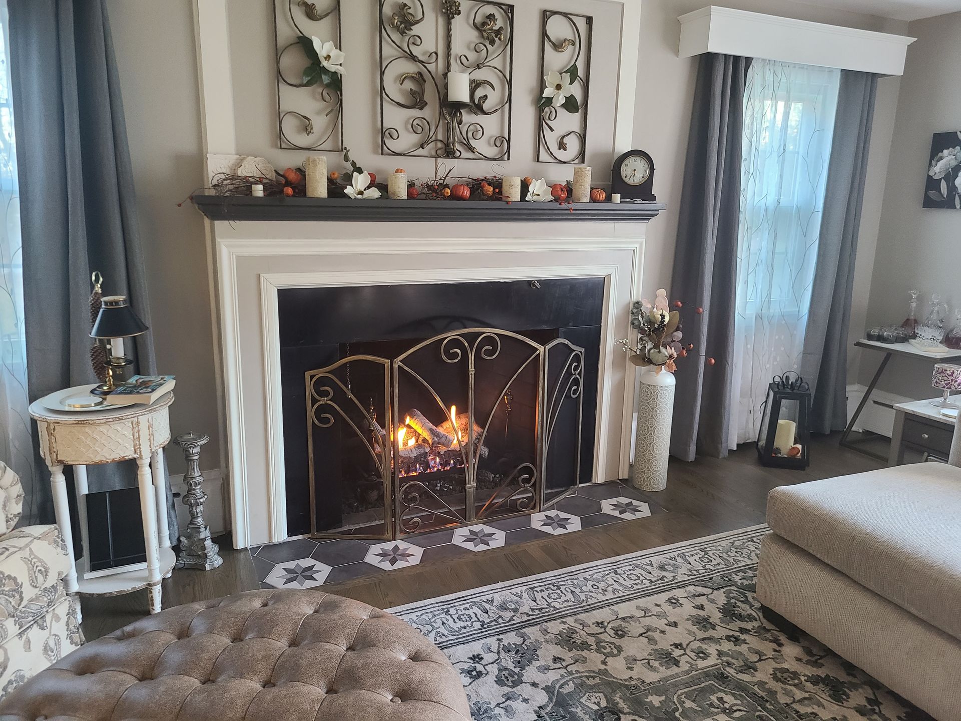 A living room with a fireplace and a clock on the mantle.