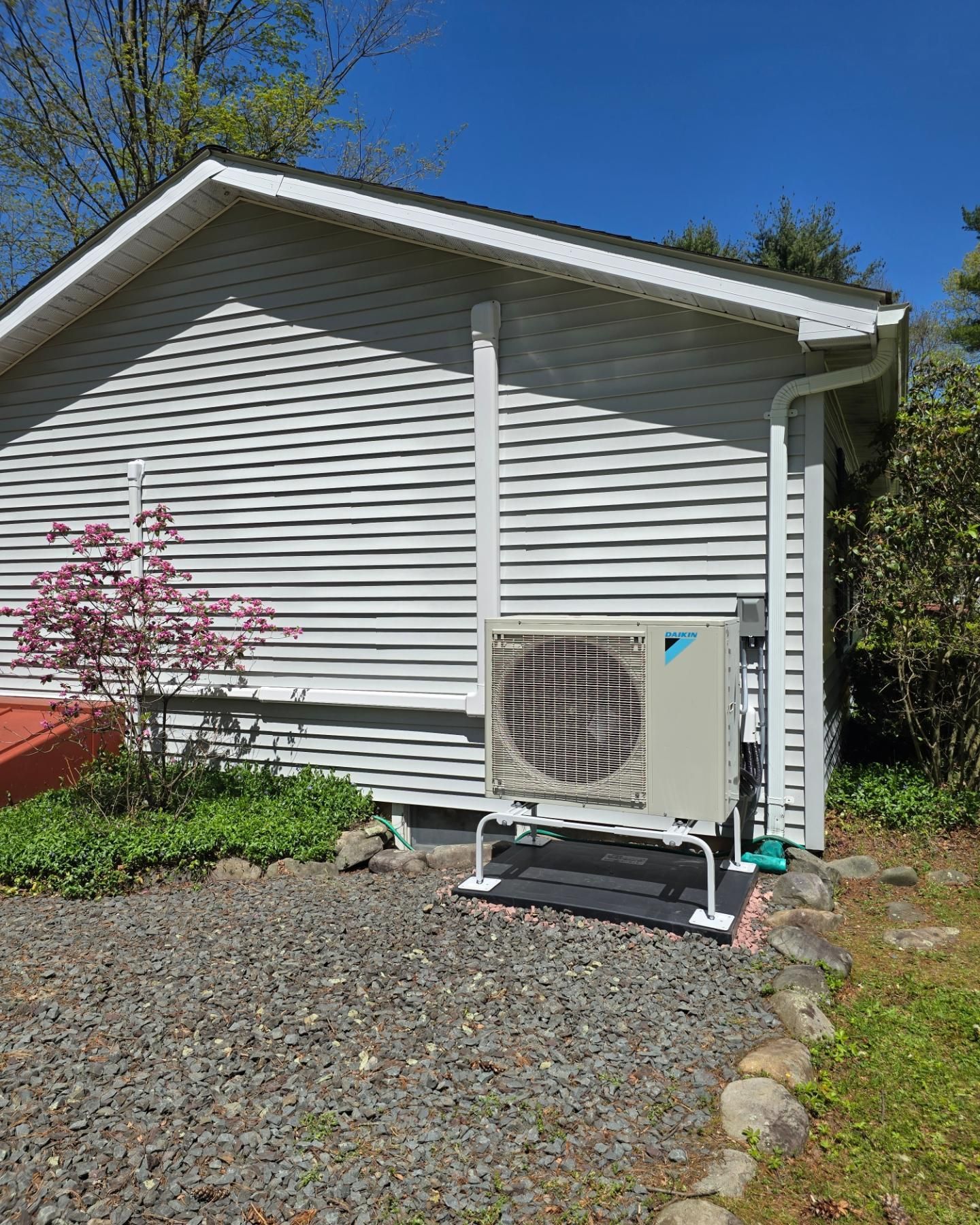 A white house with a large air conditioner on the side of it.