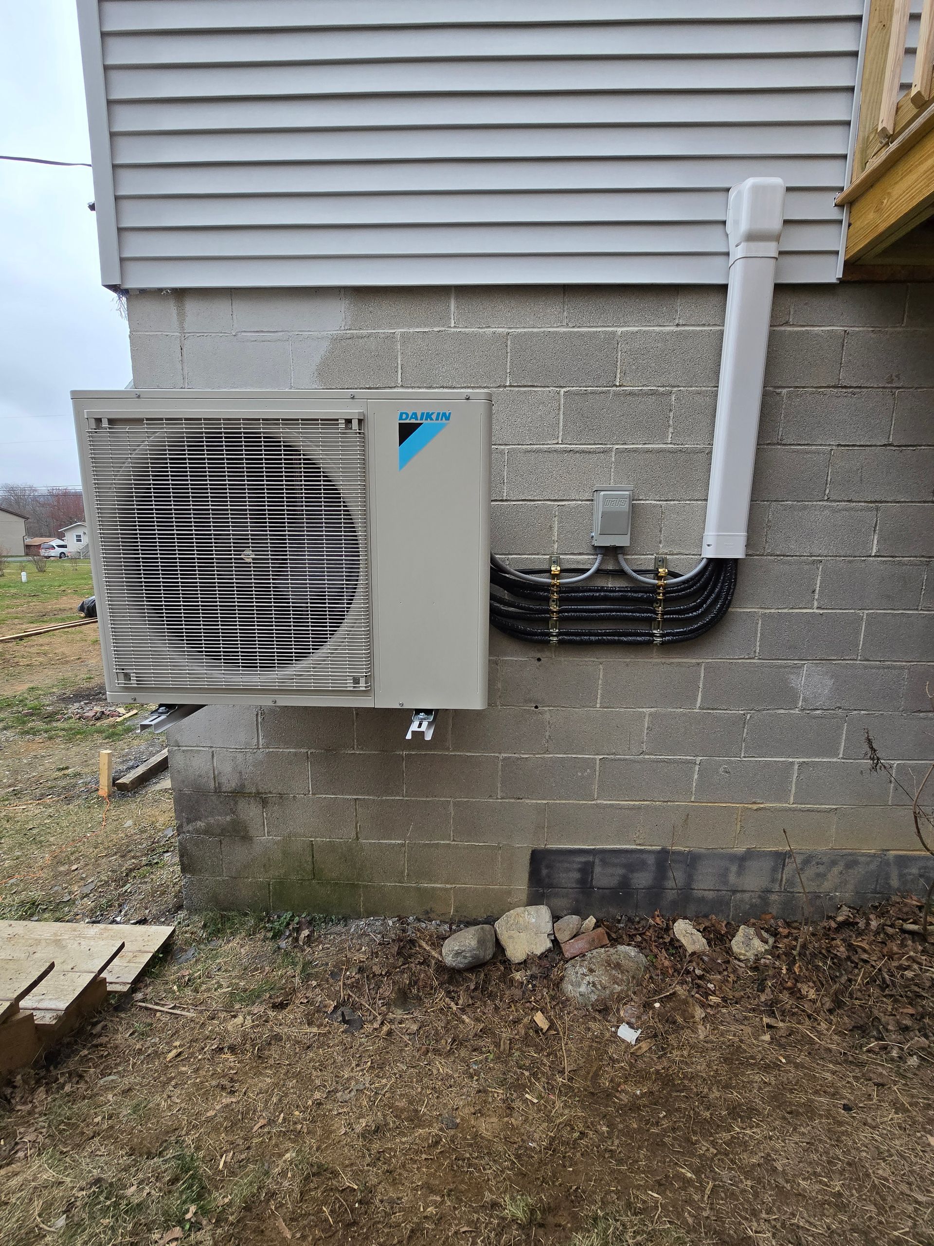 A large air conditioner is mounted on the side of a brick building.