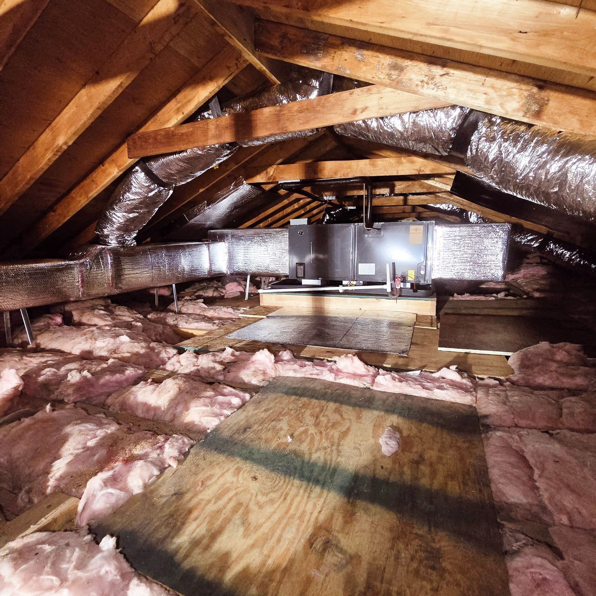 An attic with a lot of insulation and ducts