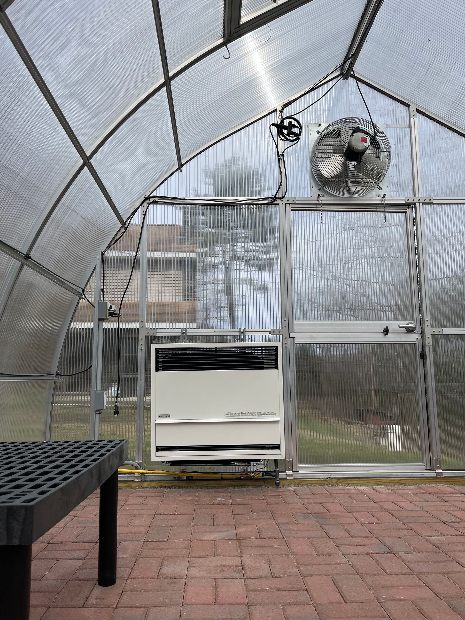 A greenhouse with a fan hanging from the ceiling.