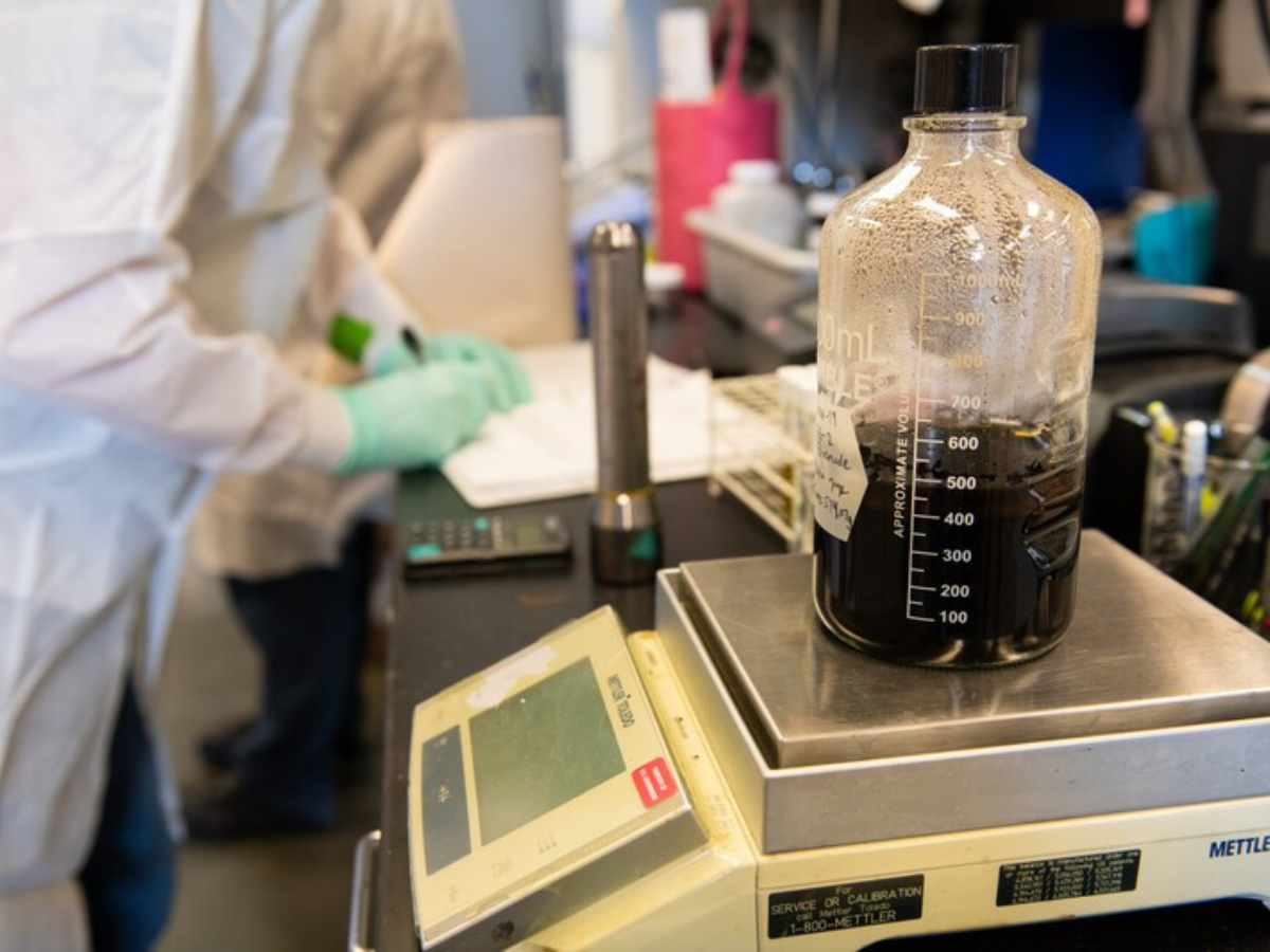 A bottle of liquid is sitting on top of a scale.