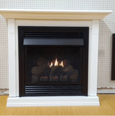 A fireplace with a white mantle is lit up