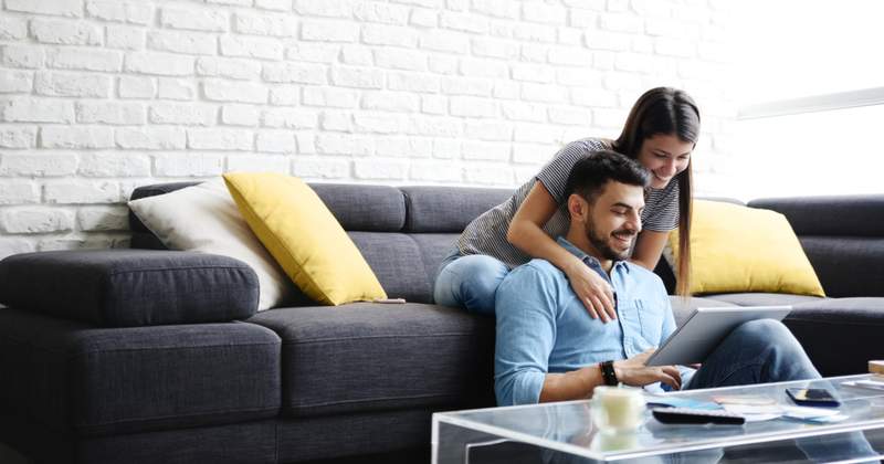 man and woman in living room looking at a tablet