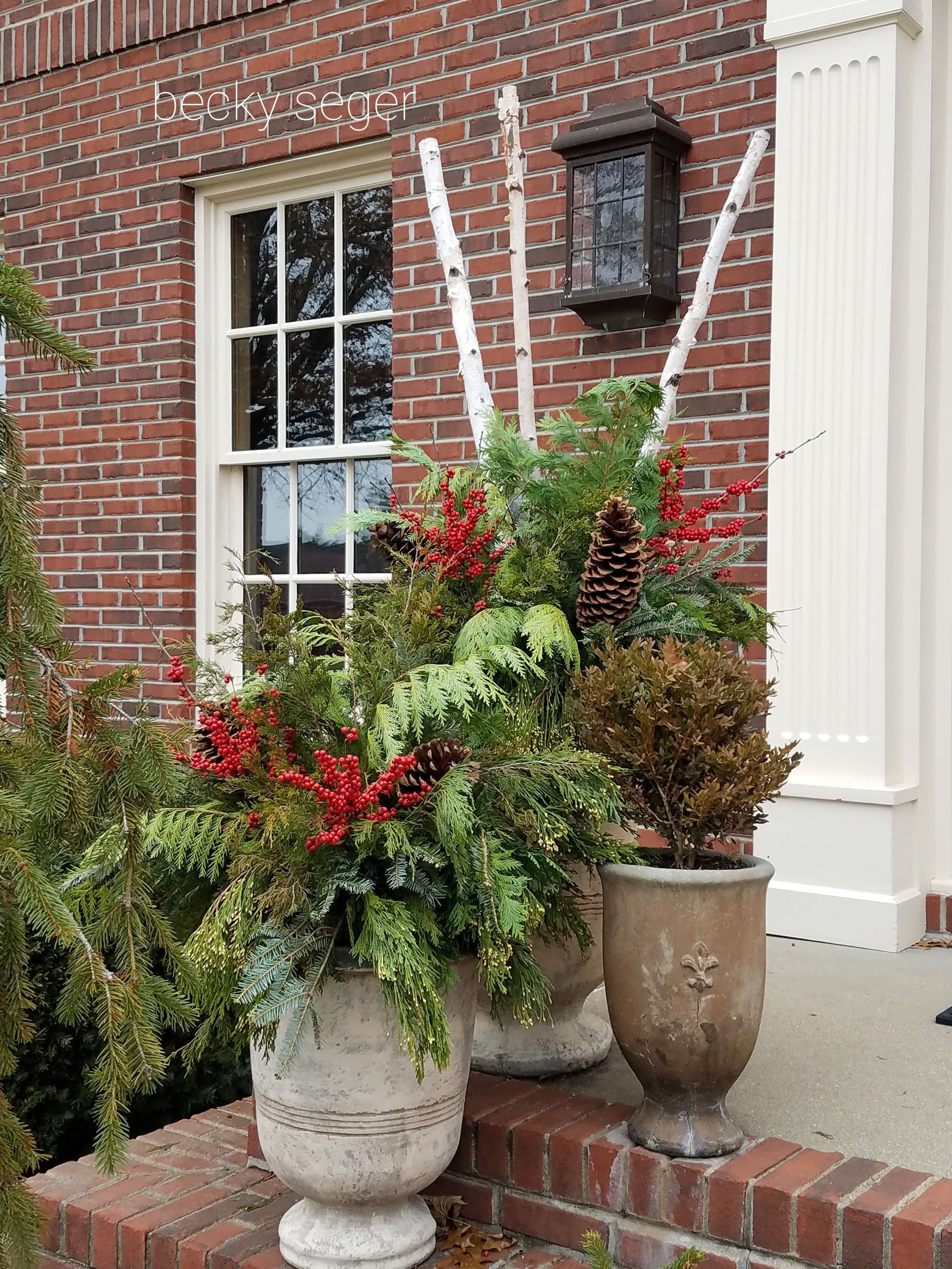 A Brick Building with a Planter Filled with Flowers in front of it  — Jasper, IN — Green Thumb Landscaping and Garden Center 