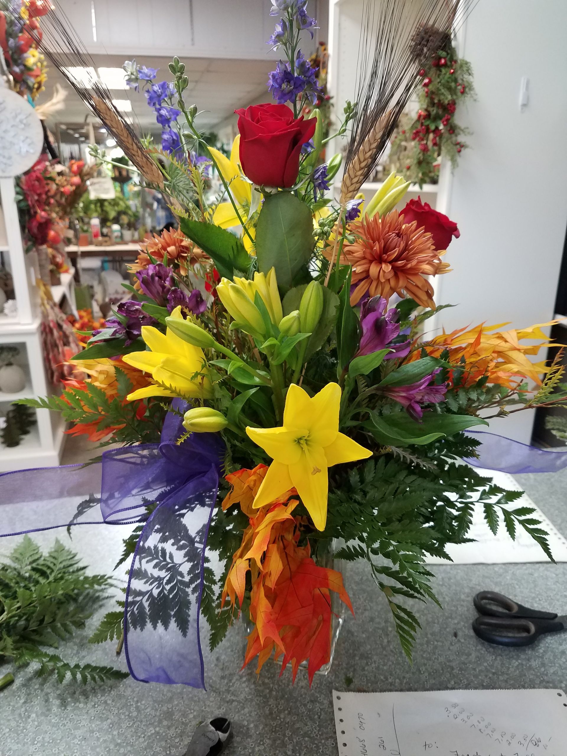 A Vase Filled with Colorful Flowers is Sitting on a Table  — Jasper, IN — Green Thumb Landscaping and Garden Center 