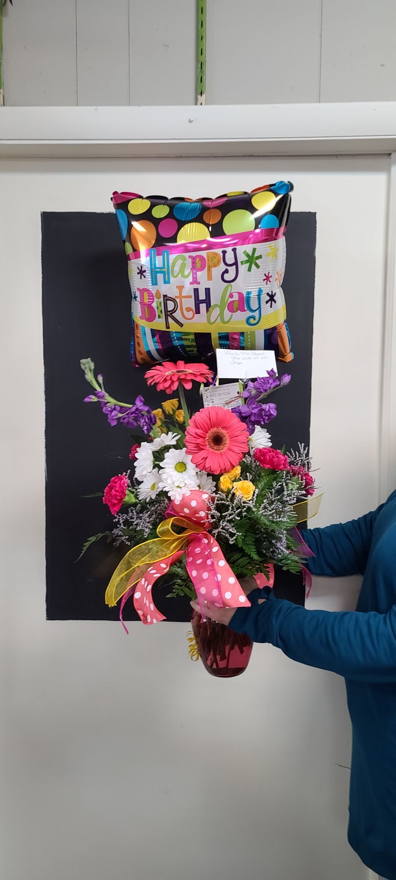 A Person is Holding a Vase of Flowers and a Happy Birthday Balloon  — Jasper, IN — Green Thumb Landscaping and Garden Center 