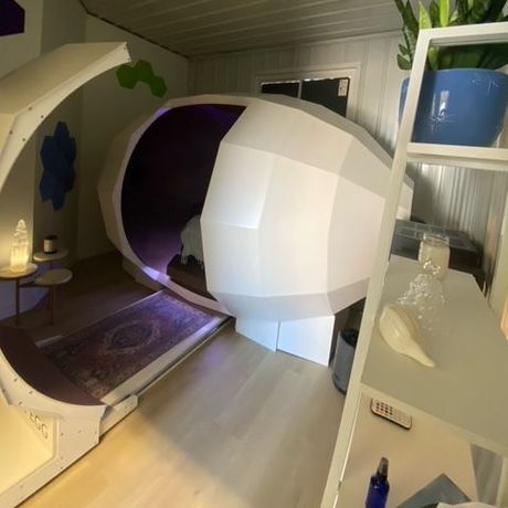 A purple and white room with a large white harmonic egg