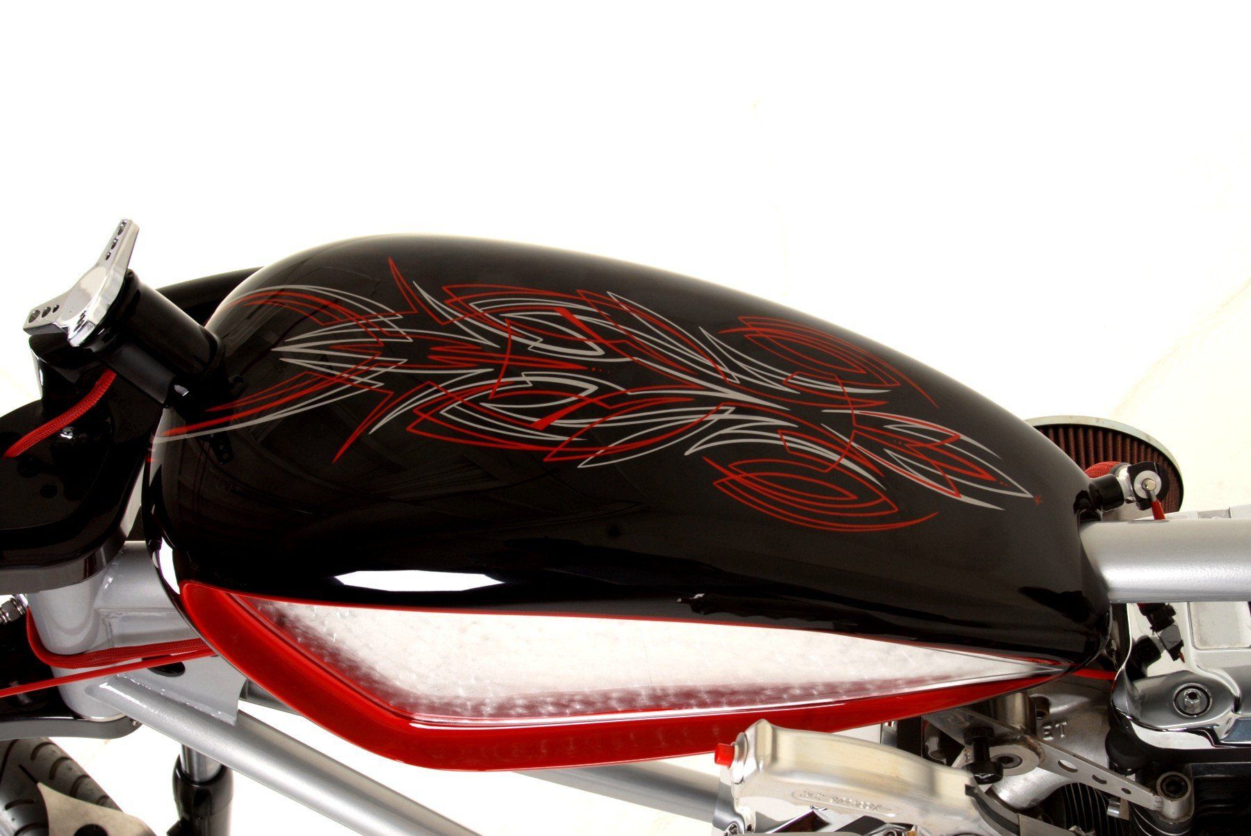 A close up of a black and red motorcycle tank