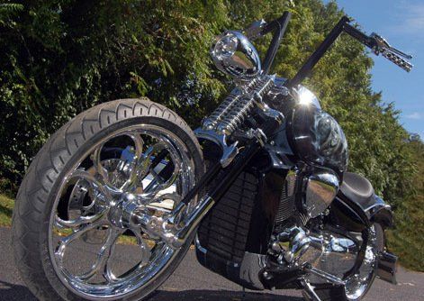 A chrome motorcycle is parked on the side of the road