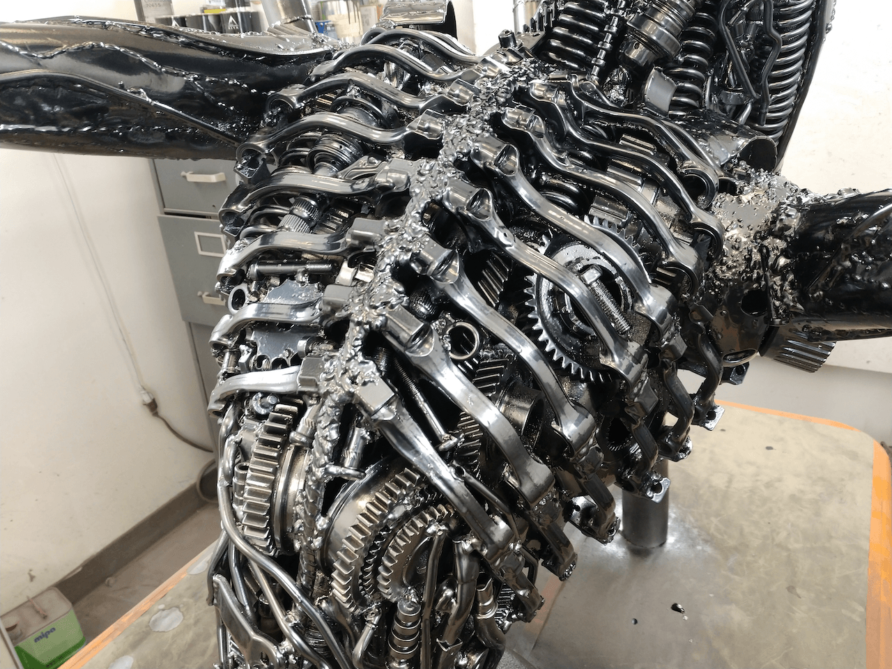 A statue of an alien made out of metal is sitting on a table.