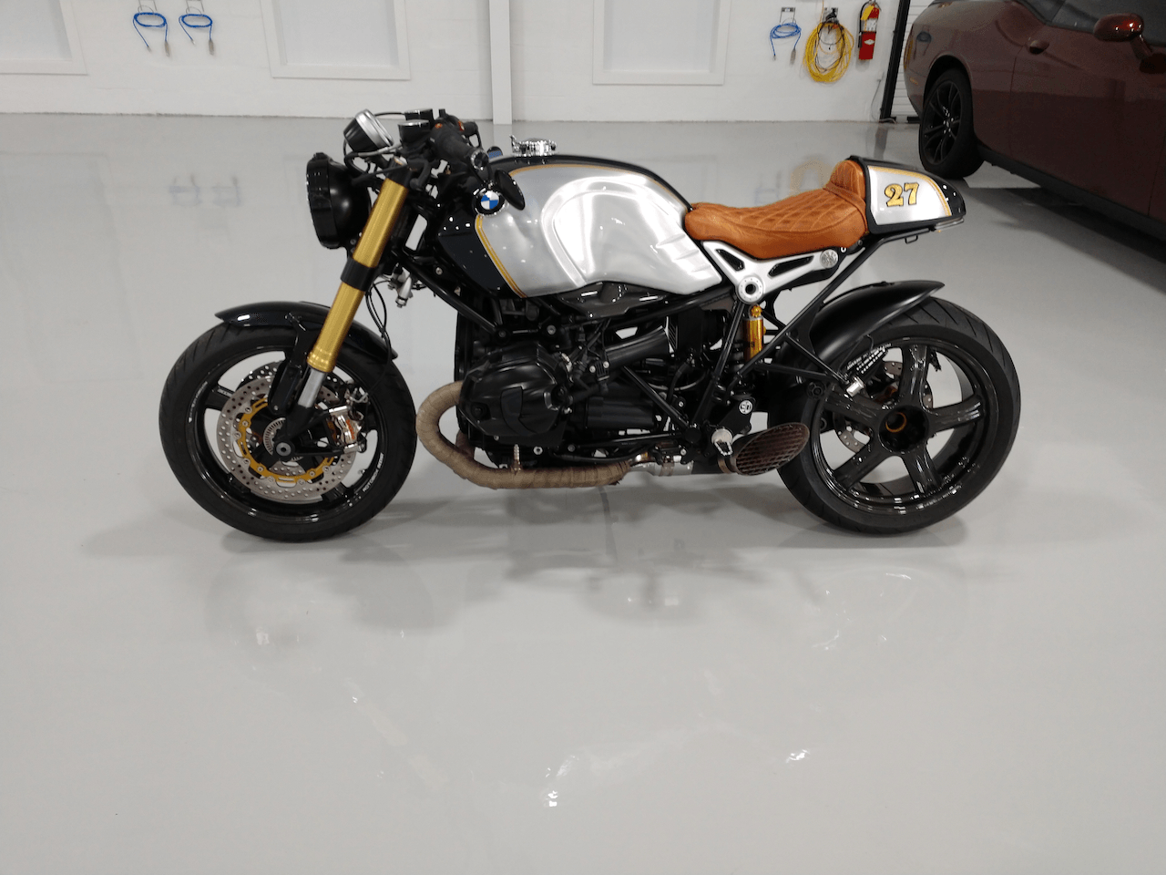 A motorcycle with the number 87 on the back is parked in a garage.