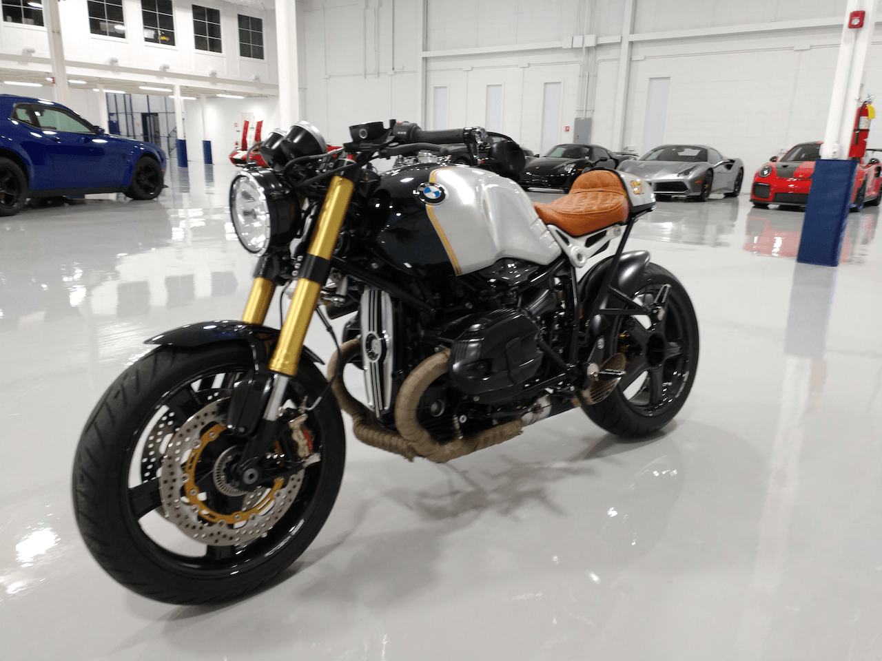 A motorcycle is parked in a garage next to cars.