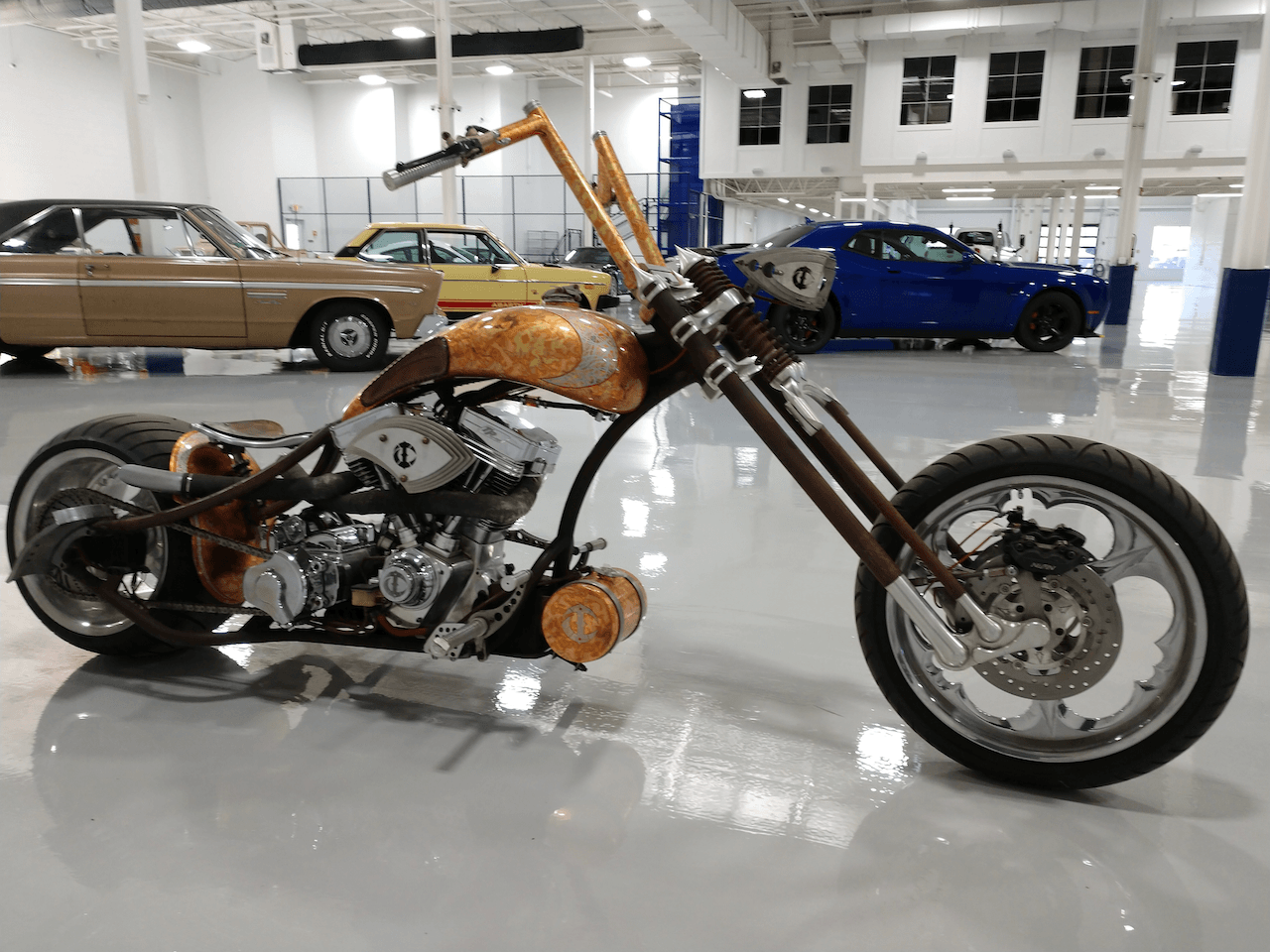A motorcycle is parked in a garage next to a car.