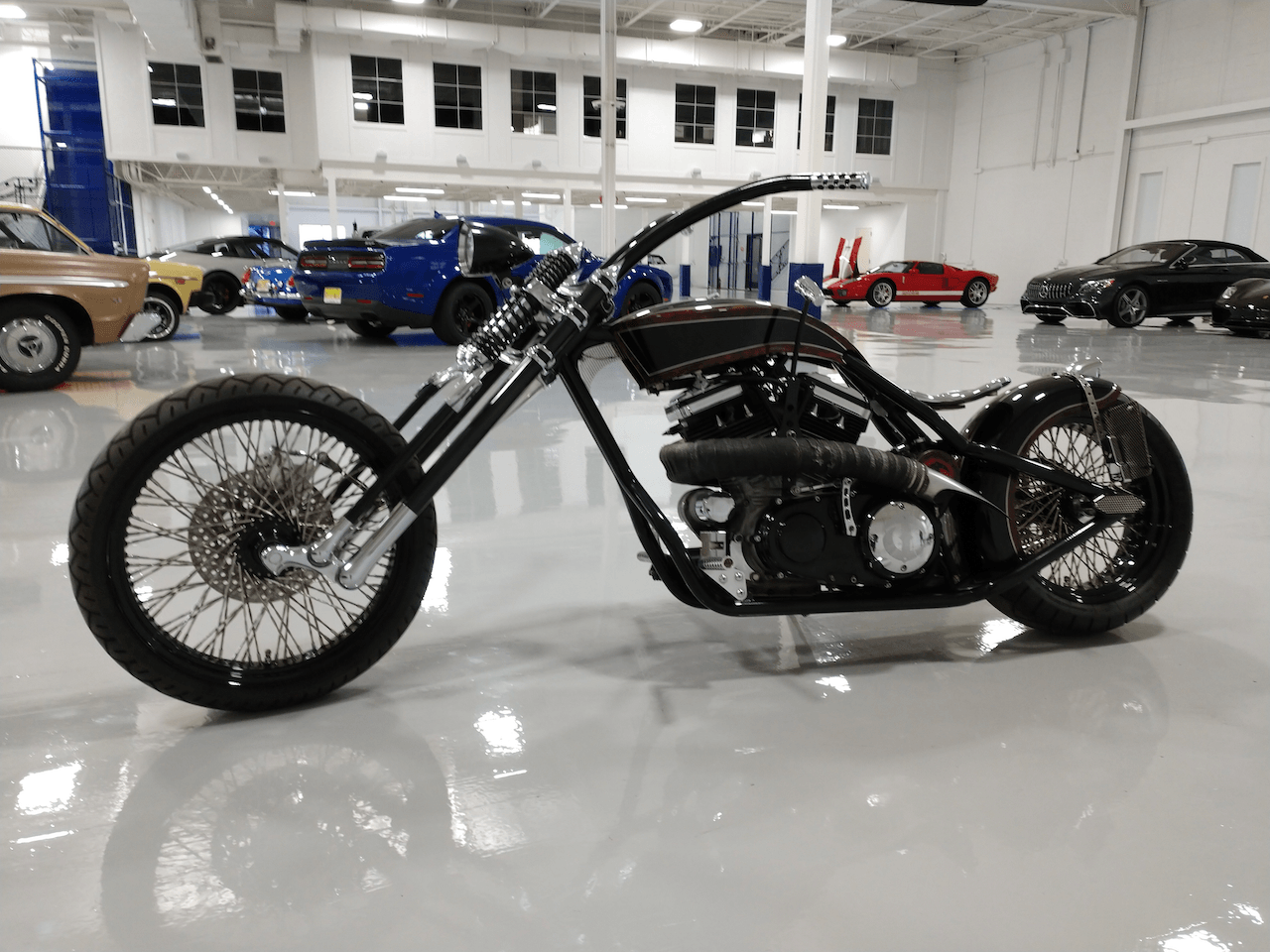 A black chopper motorcycle is parked in a garage