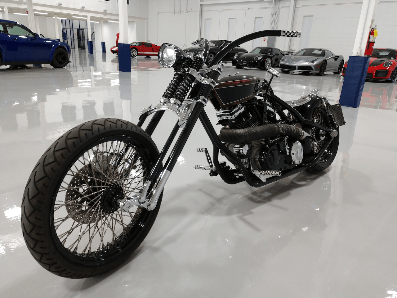 A black chopper motorcycle is parked in a garage.