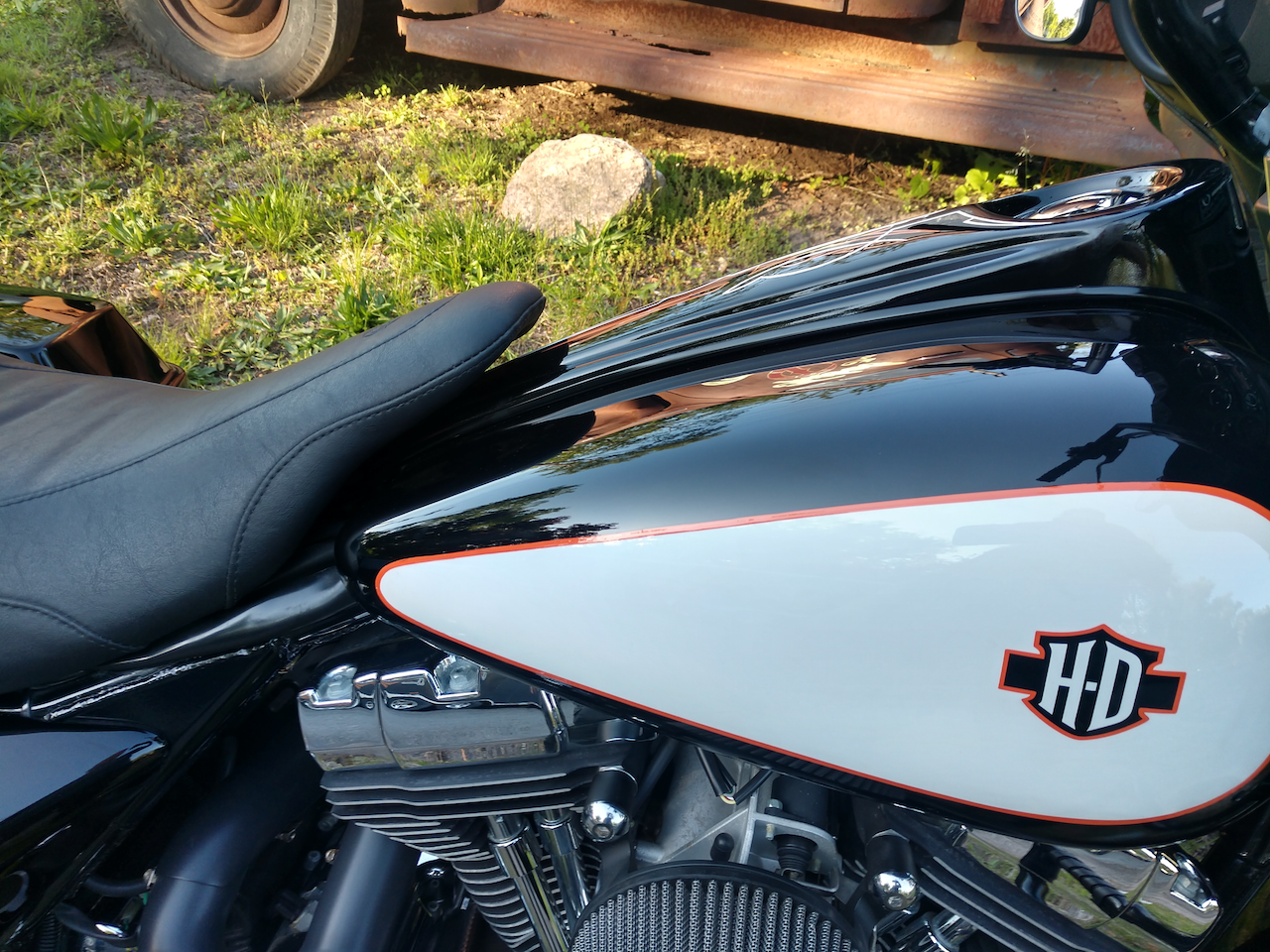 A black and white harley davidson motorcycle is parked in the grass