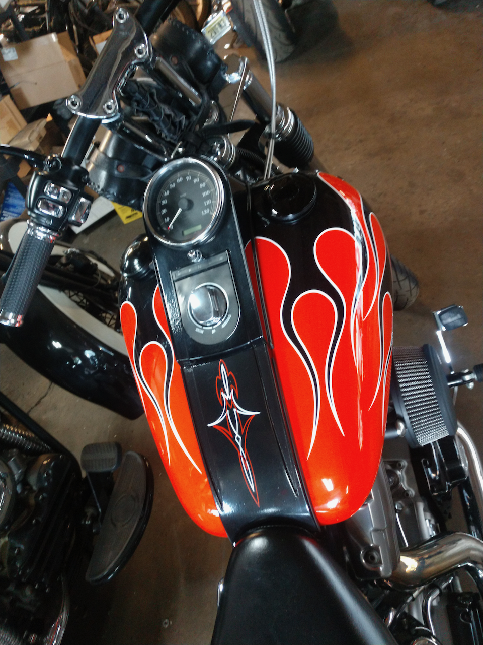 A black and orange motorcycle with flames painted on the tank