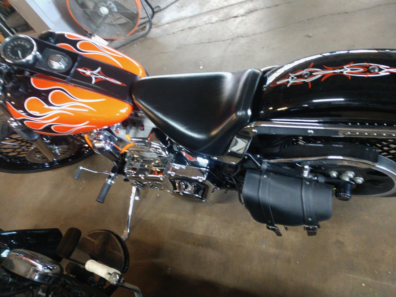 A black and orange motorcycle with flames on the tank