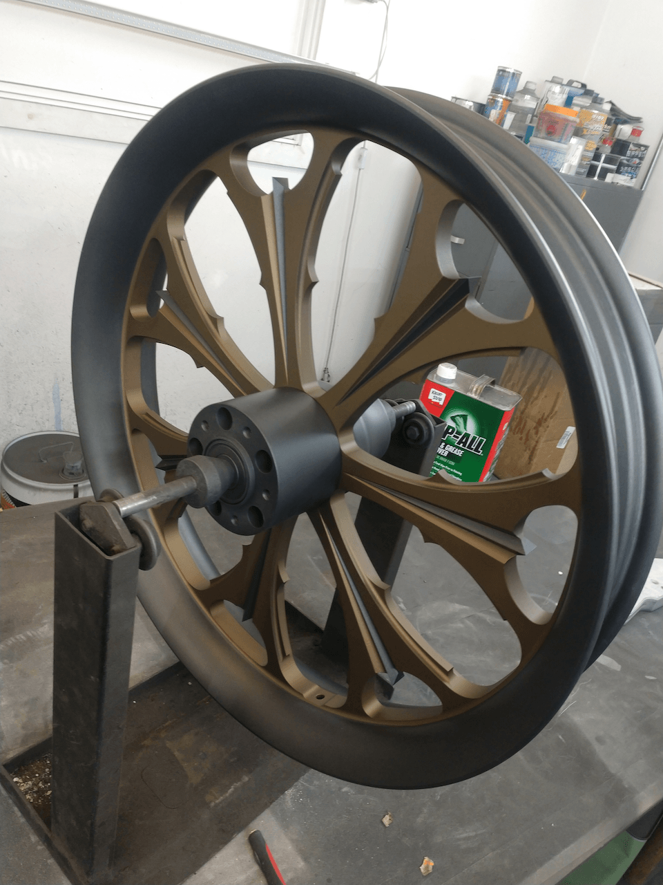 A large wheel is sitting on a table next to a bottle of sprite