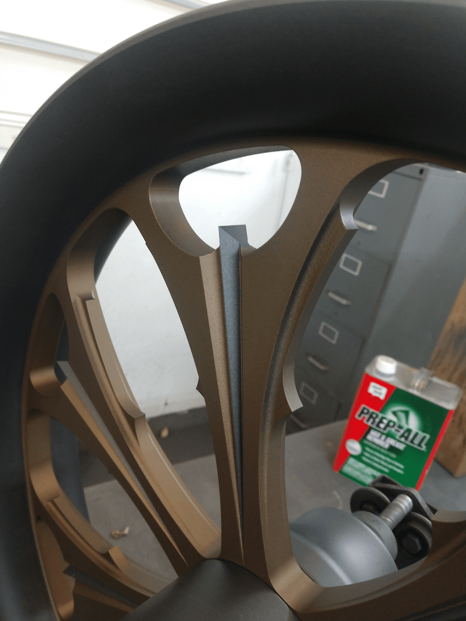 A close up of a wheel with a can of greaseball in the background