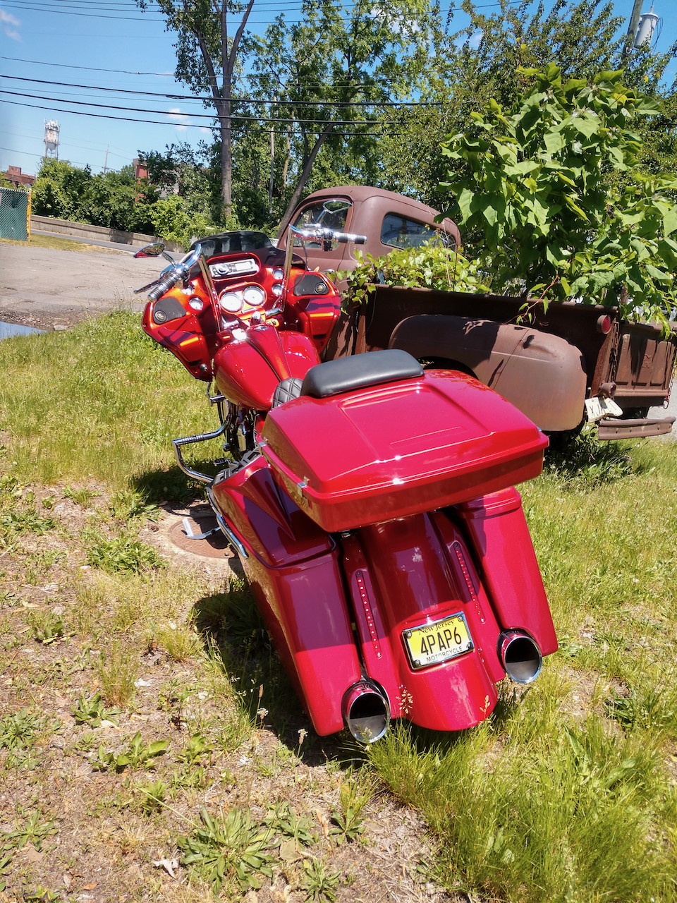 A red motorcycle is parked in a grassy field.