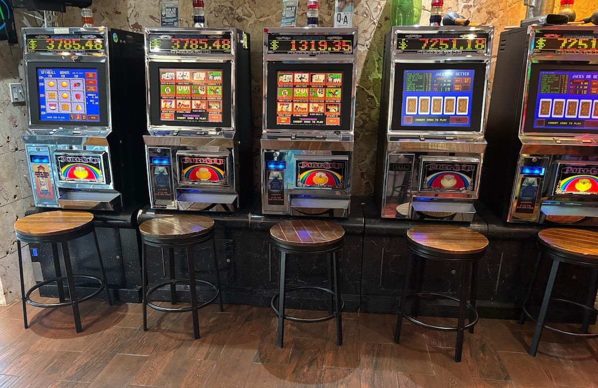 Swimming pool in front of a tan hotel building with palm trees.