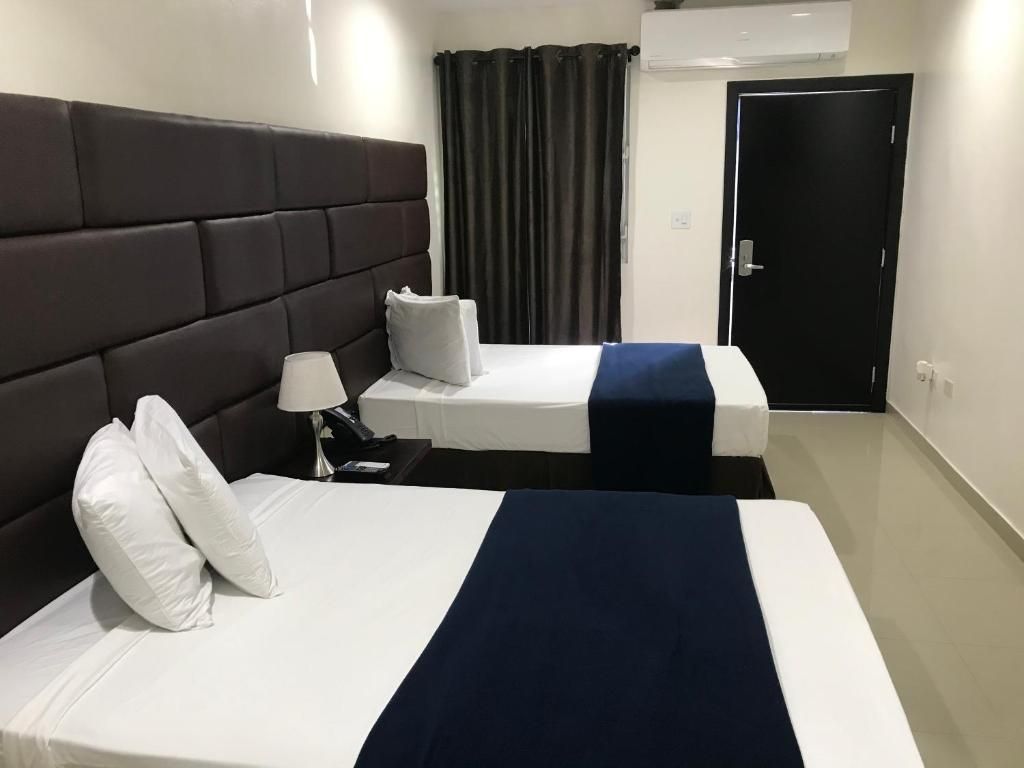 Conference room with a long table, chairs, TV, and brick wall.