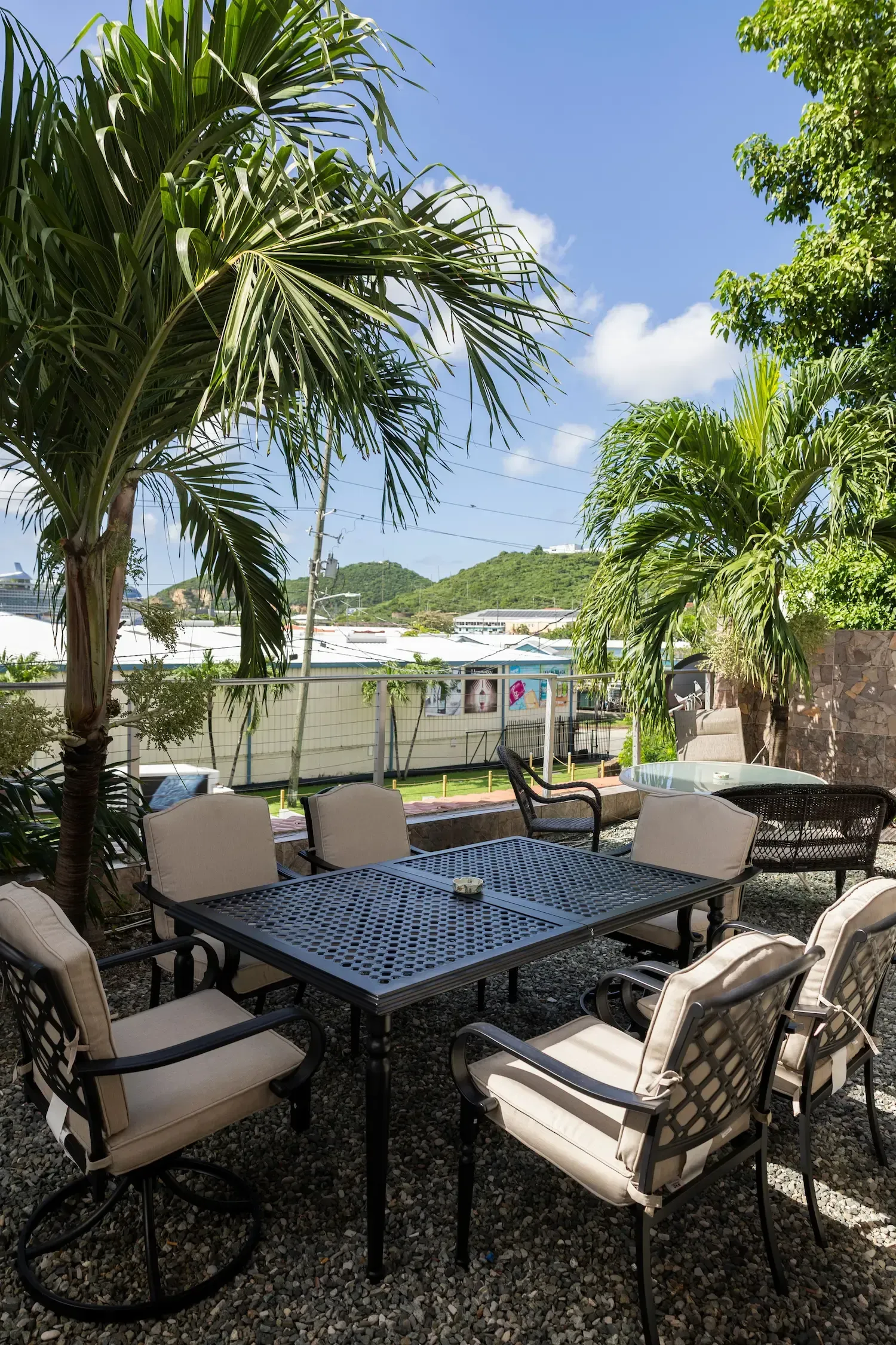 Two teal armchairs with a wooden table and lamp, with artwork on the wall.