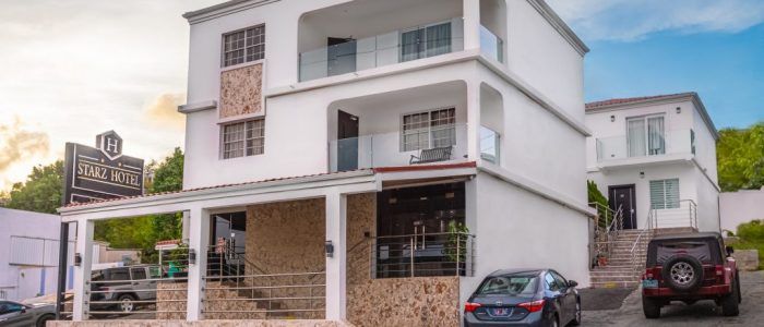 Outdoor patio with gazebos, tables, and lush landscaping, near a building.