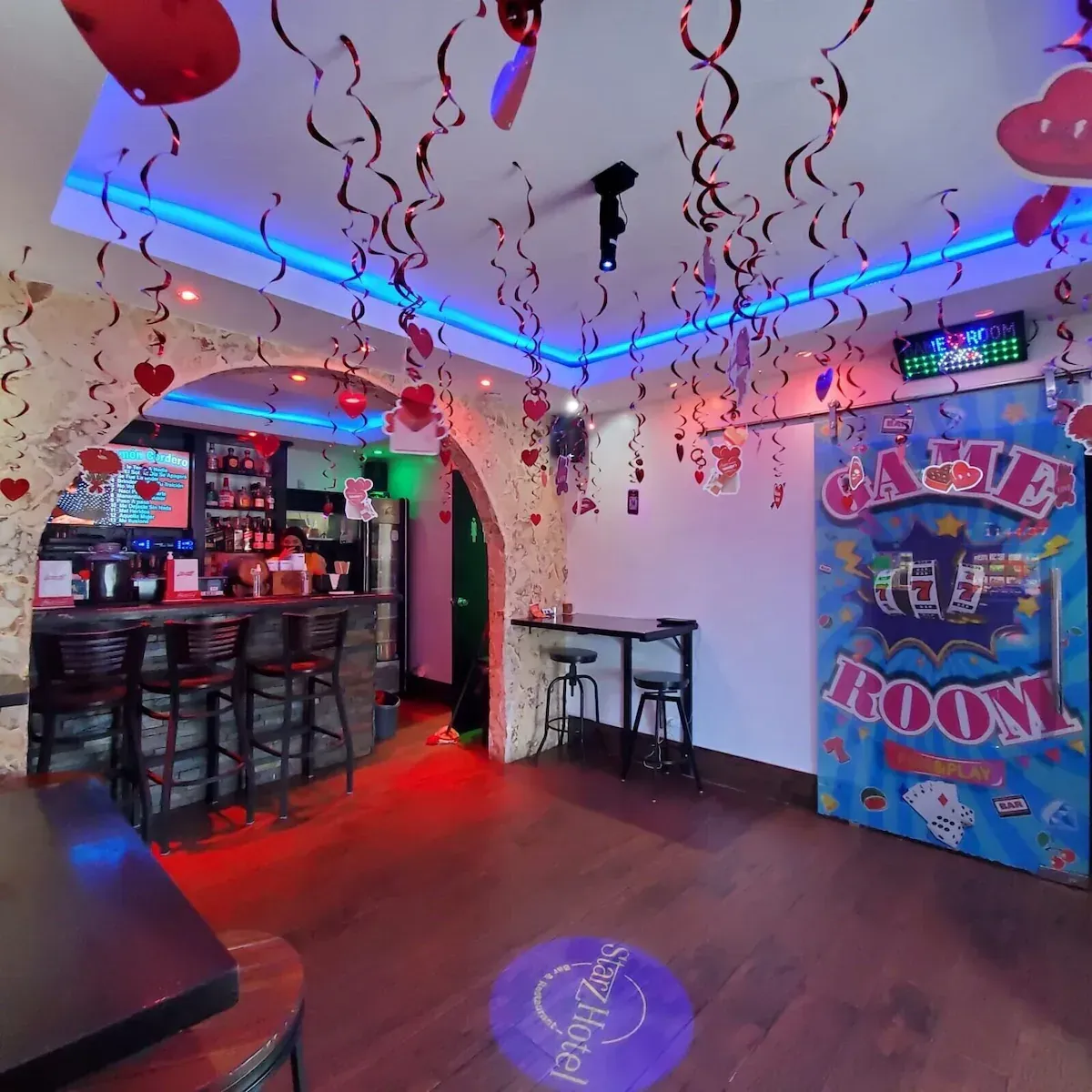 Dining room with tables, chairs, and a brown booth. Beige walls, light-colored tile floor, and exit door.