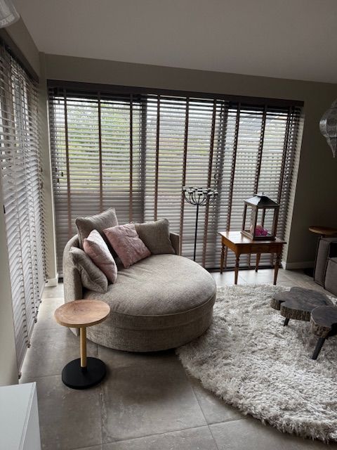 Een man zit op een bank in de woonkamer met een laptop.