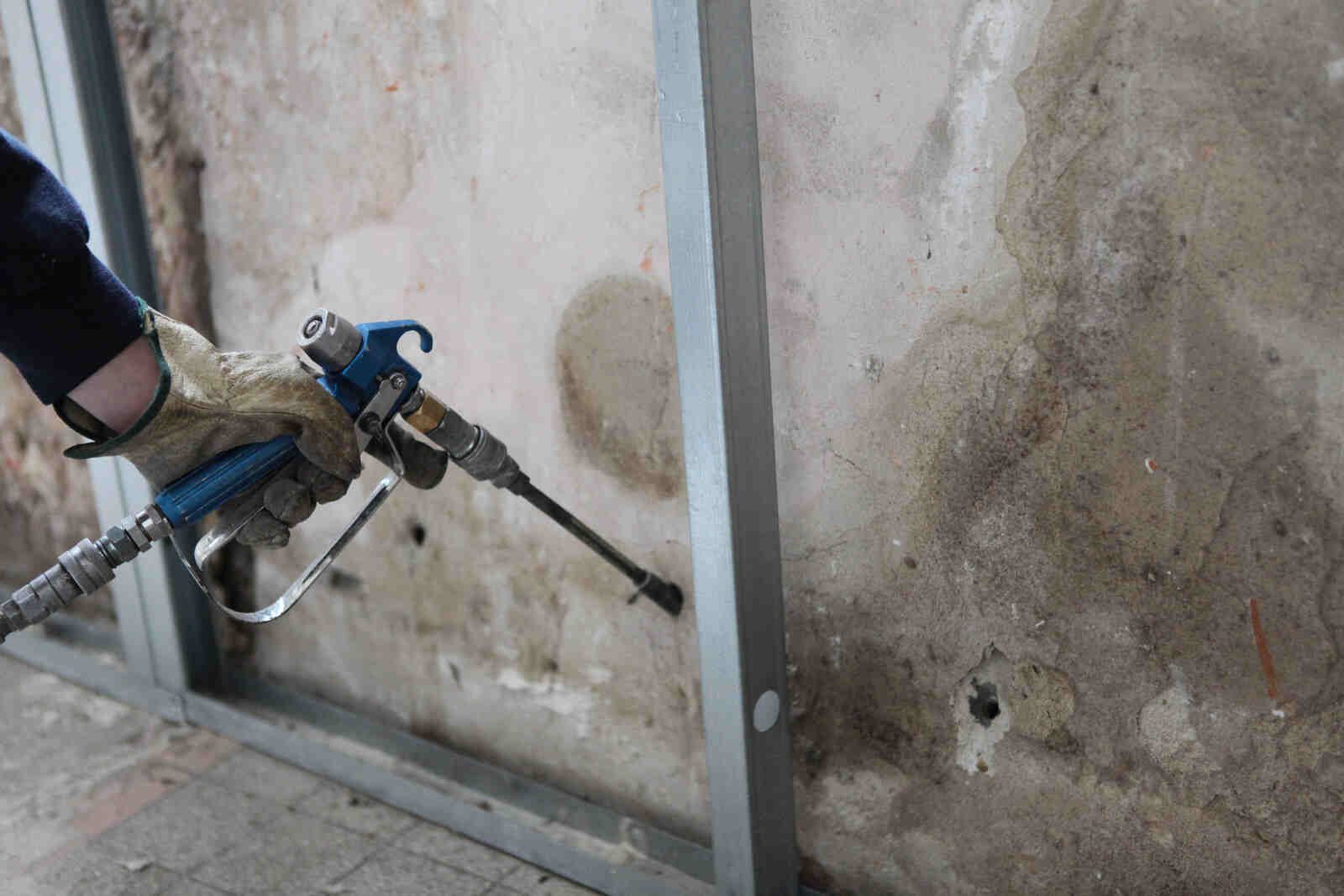 Man Spraying Insulation into a wall