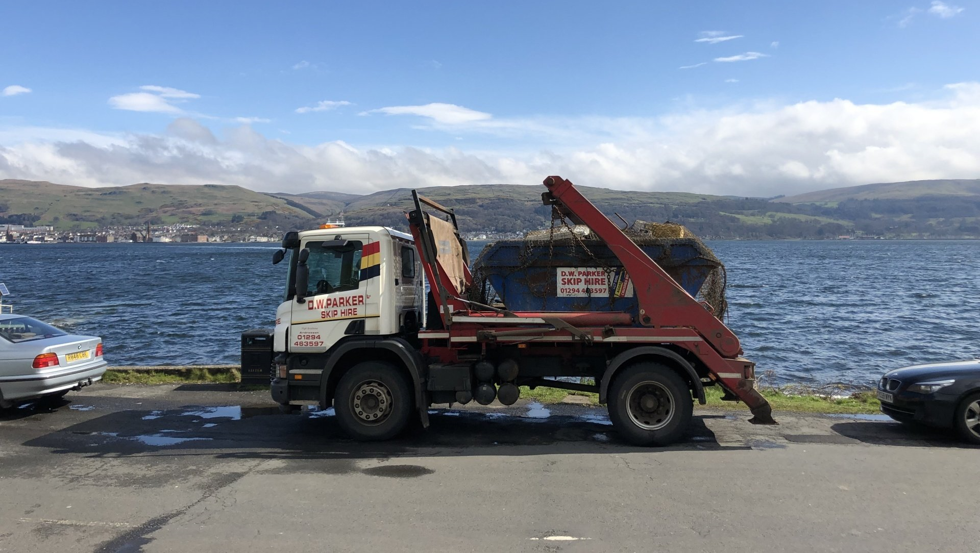 White truck and trailer beside lake