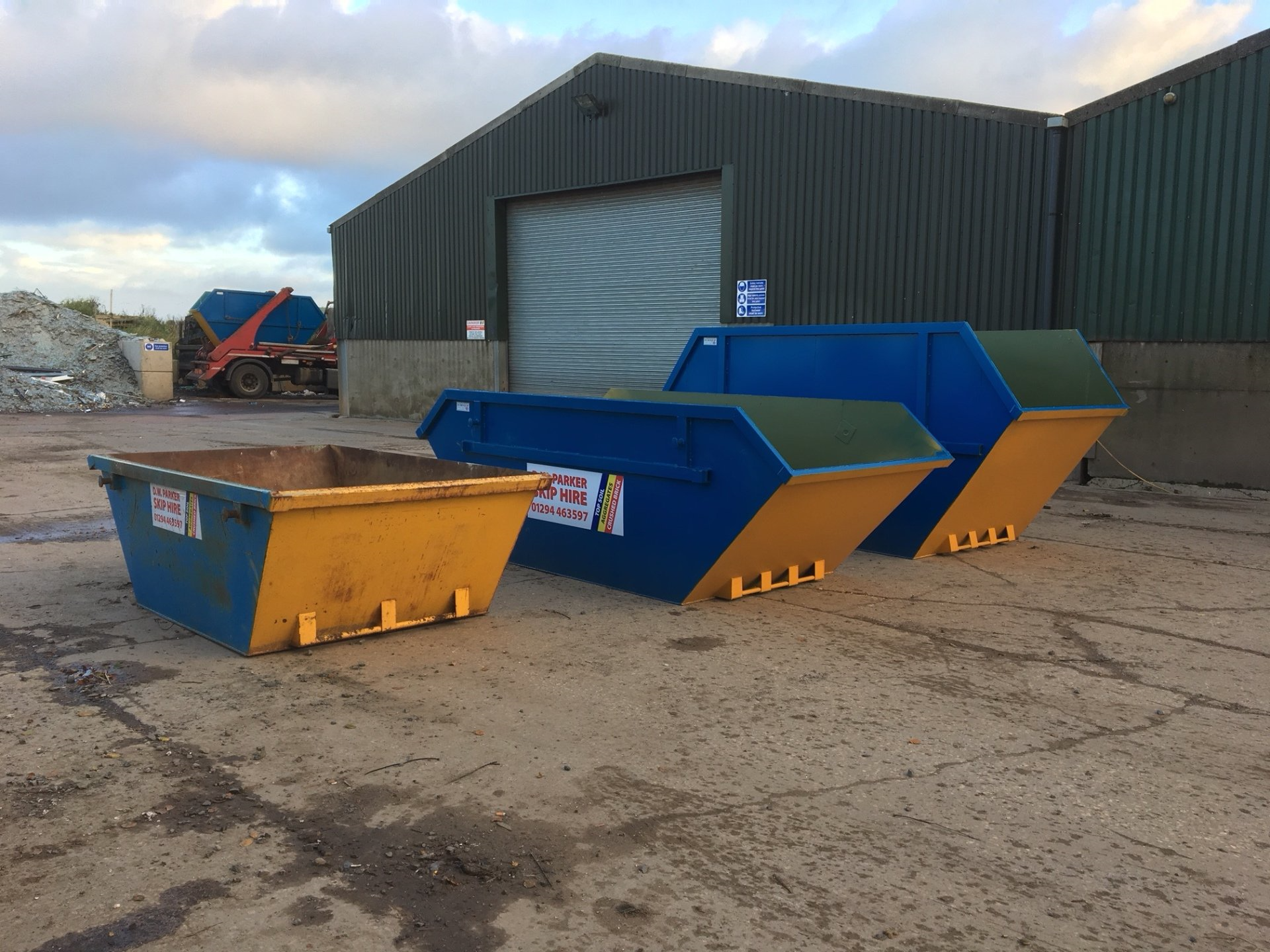Blue and yellow skips in forecourt