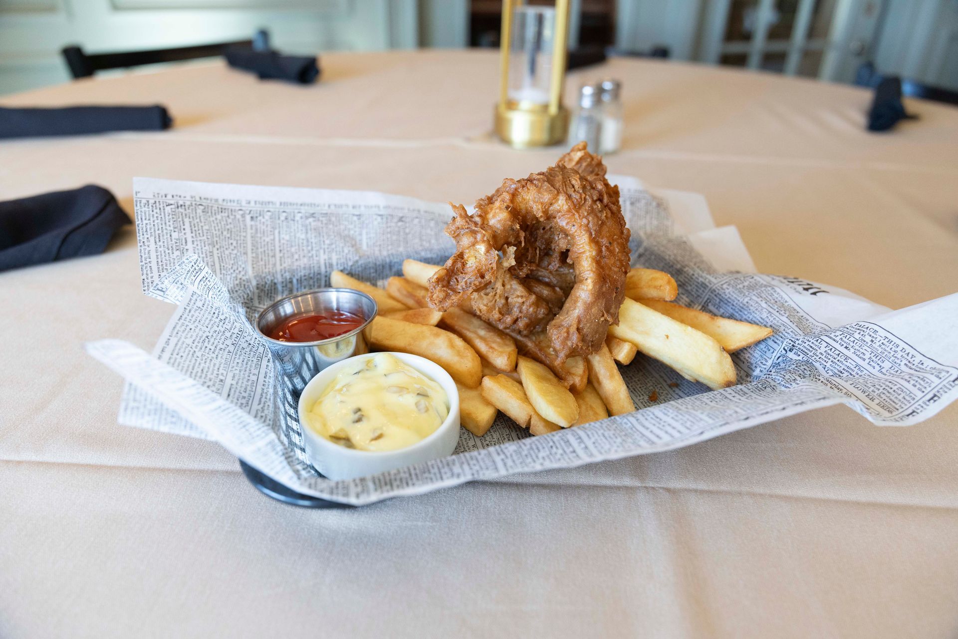 A basket of fried calamari and french fries on a table.