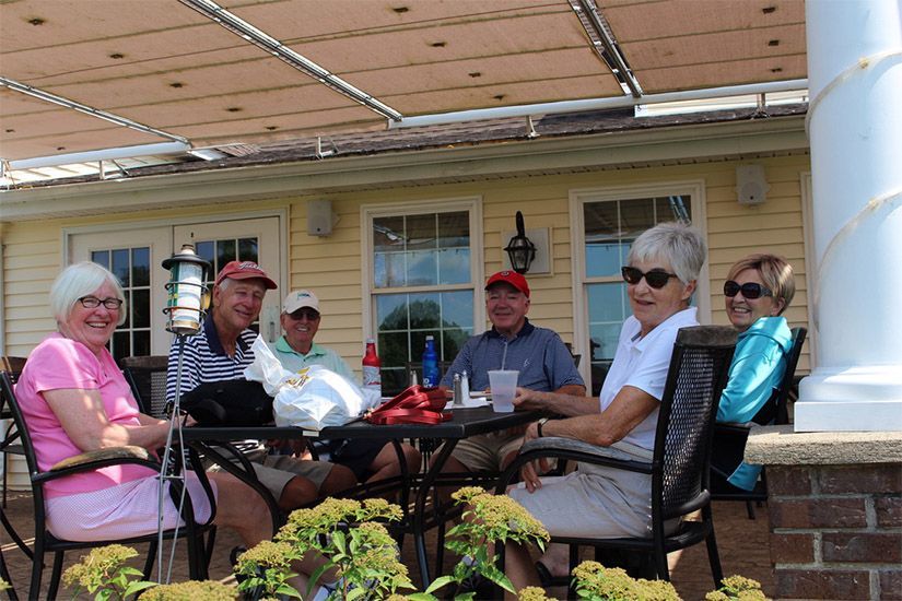 A group of people are sitting around a table outside