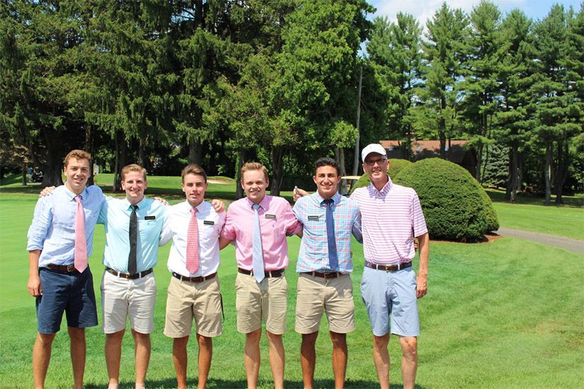 A group of young men are posing for a picture in a park.