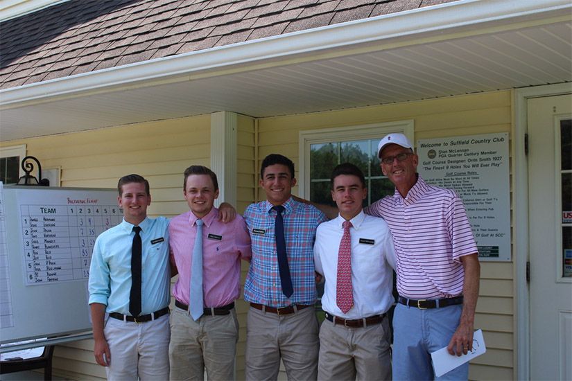 A group of men are posing for a picture in front of a building.