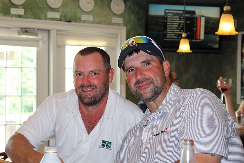 Two men are posing for a picture in a restaurant