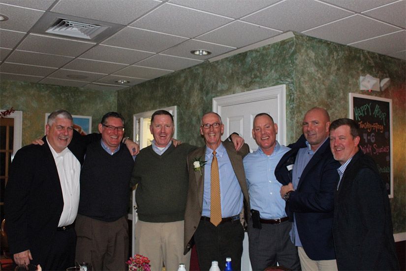 A group of men are posing for a picture in a room