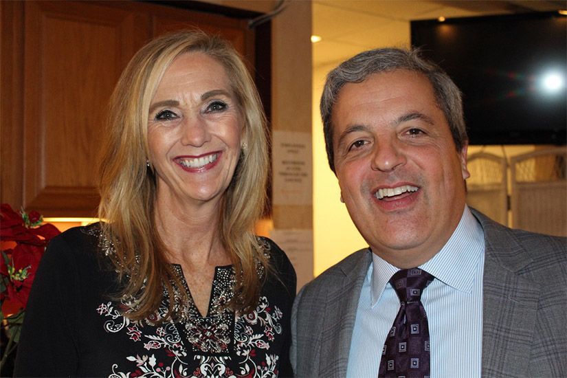 A man and a woman are posing for a picture together and smiling.