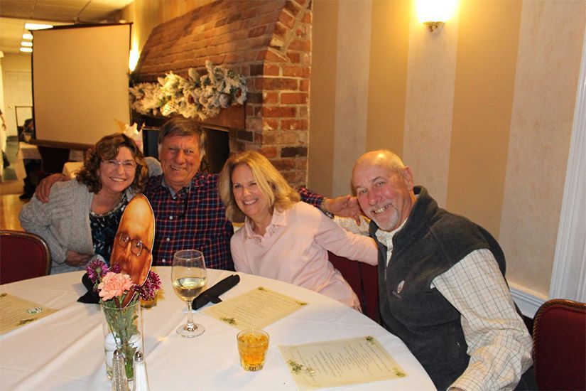 A group of people are posing for a picture at a table.