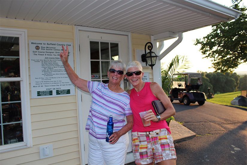 Two women standing in front of a building with a golf cart in the background