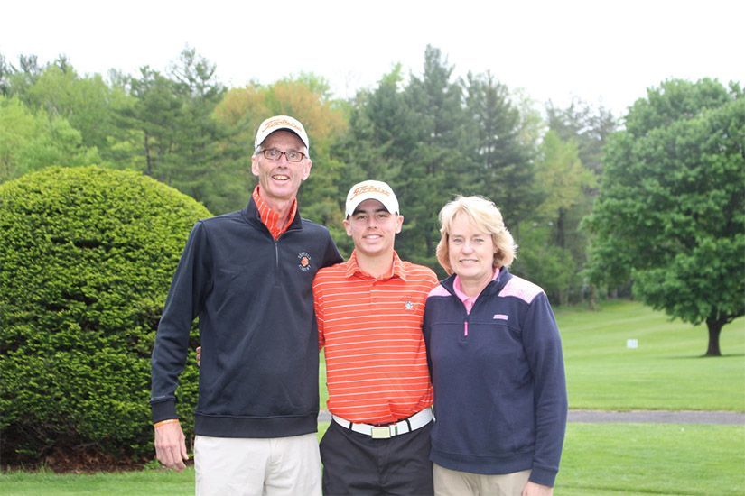 Three people are posing for a picture on a golf course.