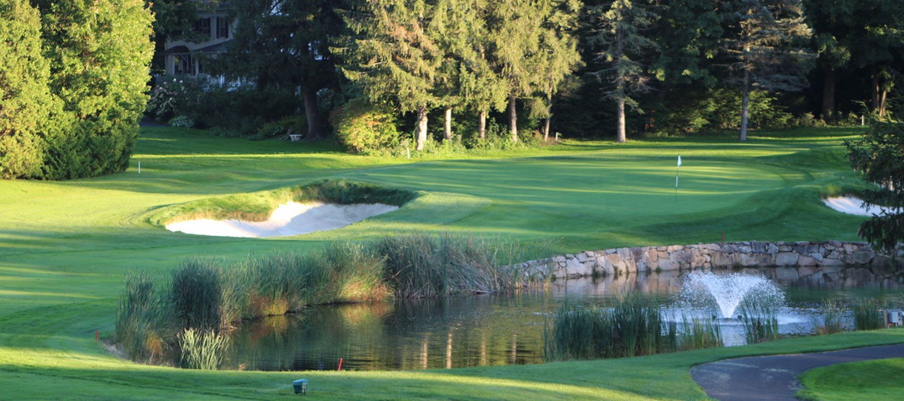 A golf course with a pond in the middle of it