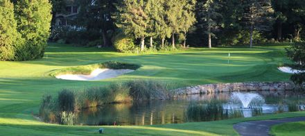A golf course with a pond in the middle of it