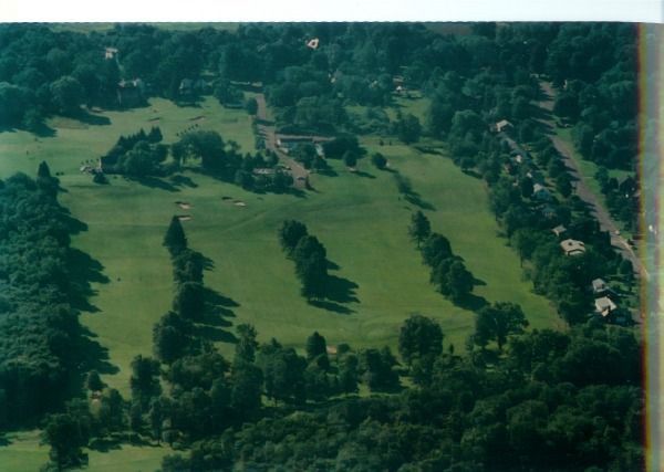 An aerial view of a golf course surrounded by trees
