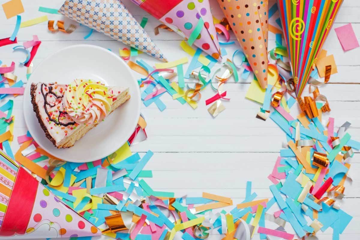 A little girl is sitting at a table with a birthday cake.